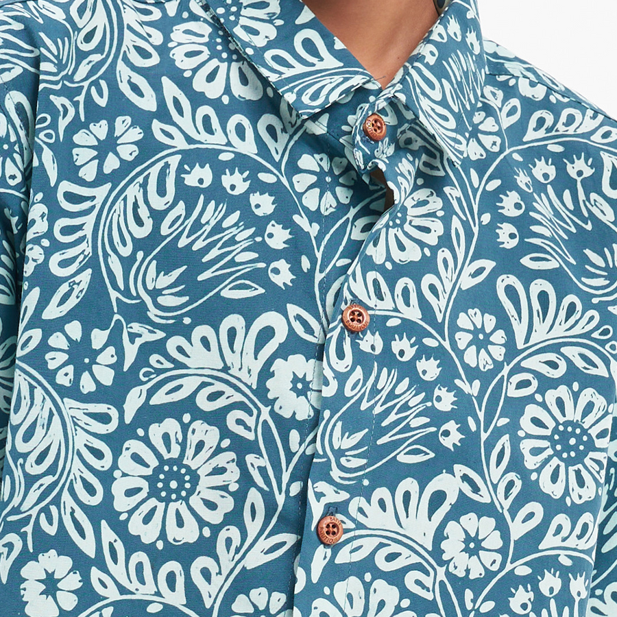 a closeup shot of a batik shirt in the pattern teal ukir