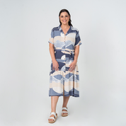 Front view of model wearing Batik Boutique’s Button-Up Dress in Lavender Bukit print, made from breathable cotton with a self-tie waist.