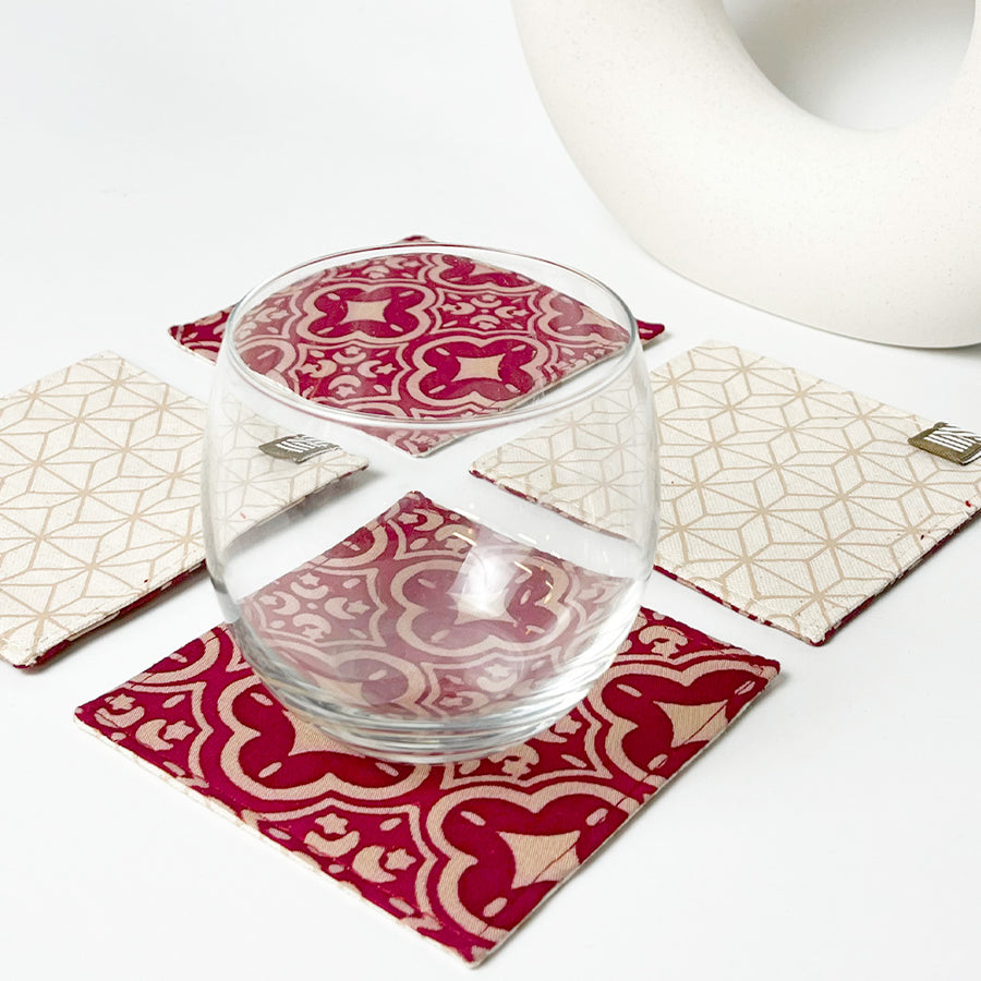 A lifestyle photo featuring a set of crimson celestial batik coasters alongside glasses, elegantly arranged and ready for serving