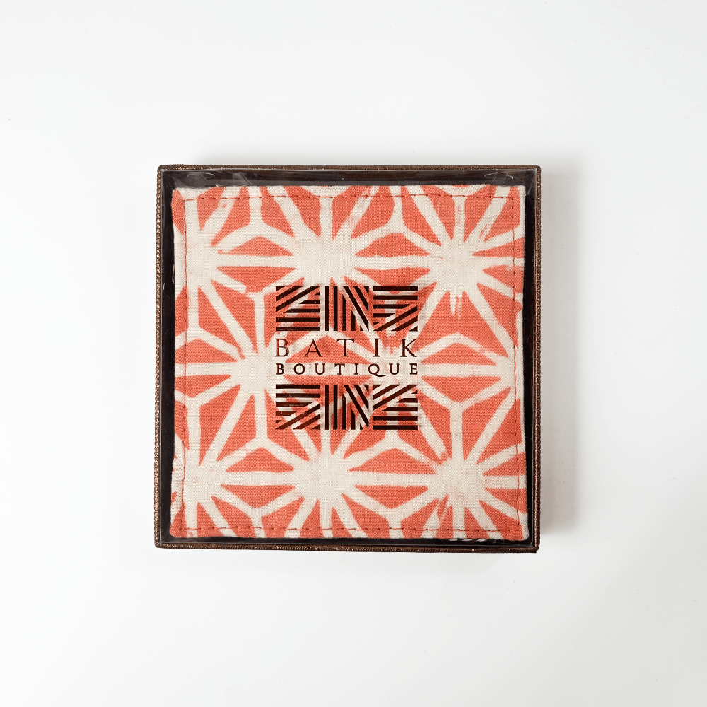 Artisan-crafted peach batik coasters with starburst pattern, set of four coasters, Square cotton coasters featuring peach firework batik design, reversible sides in matching tones, handcrafted by Malaysian artisans. Peach and white batik coasters in starburst motif, reversible fabric with Batik Boutique logo box, ideal for home décor or gifting. Perfect for  drinking, parties, Events
Stocking stuffer