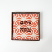 Artisan-crafted peach batik coasters with starburst pattern, set of four coasters, Square cotton coasters featuring peach firework batik design, reversible sides in matching tones, handcrafted by Malaysian artisans. Peach and white batik coasters in starburst motif, reversible fabric with Batik Boutique logo box, ideal for home décor or gifting. Perfect for  drinking, parties, Events
Stocking stuffer