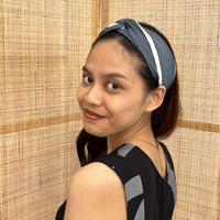 A model is wearing batik headband in grey brush print. Made from batik remnant fabric