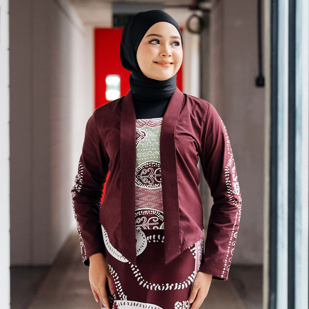 Maroon Petola Batik Kebaya Jacket – A model wearing a handcrafted maroon batik kebaya jacket with elegant detailing