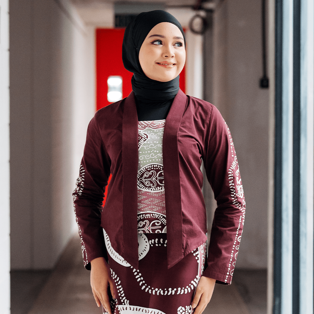 Maroon Petola Batik Kebaya Jacket – A model wearing a handcrafted maroon batik kebaya jacket with elegant detailing