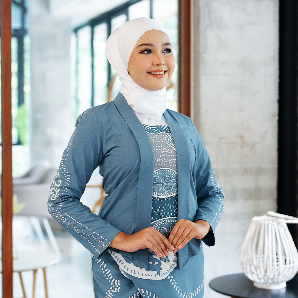 Slate Petola Batik Kebaya Jacket – A model wearing a handcrafted batik kebaya jacket in a soft slate blue shade, styled elegantly