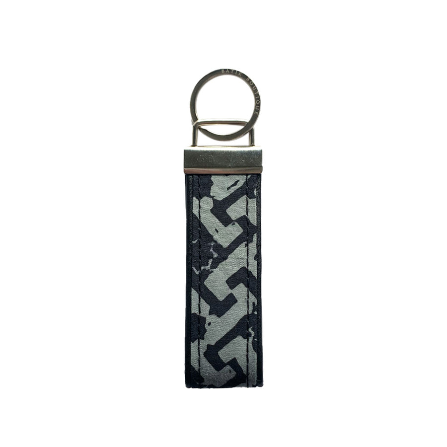A frontside photo of batik key fob in grey arabesque on a white color background
