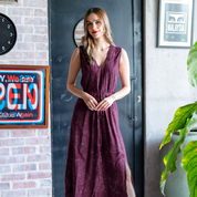 a woman in a lifestyle photo wearing a batik max dress in a plum orchid pattern