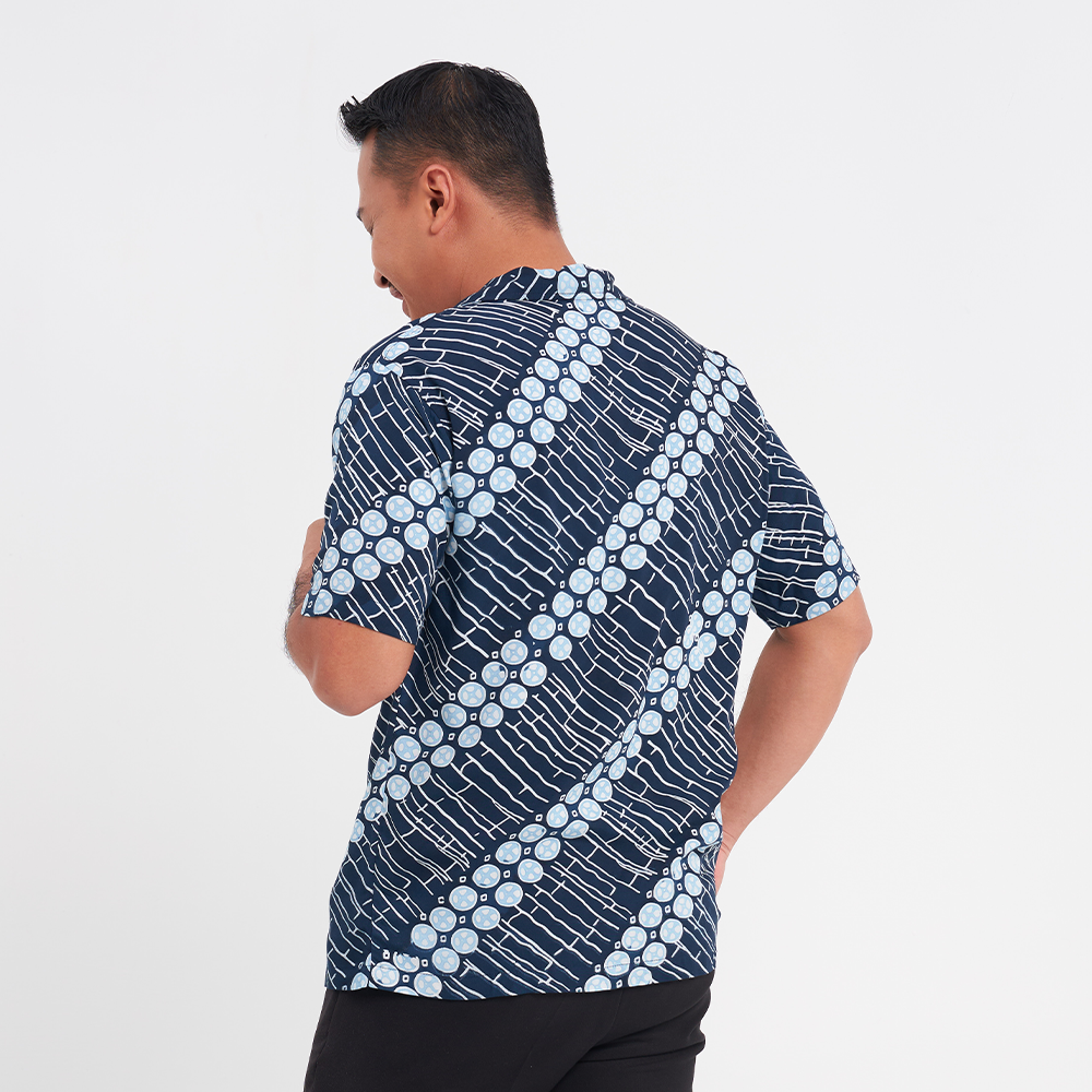 a male model facing away to show the closeup up of the batik cuban shirt in the pattern navy buluh