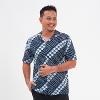 a male model posing in front of a white background while in a cuban batik shirt in the pattern navy buluh