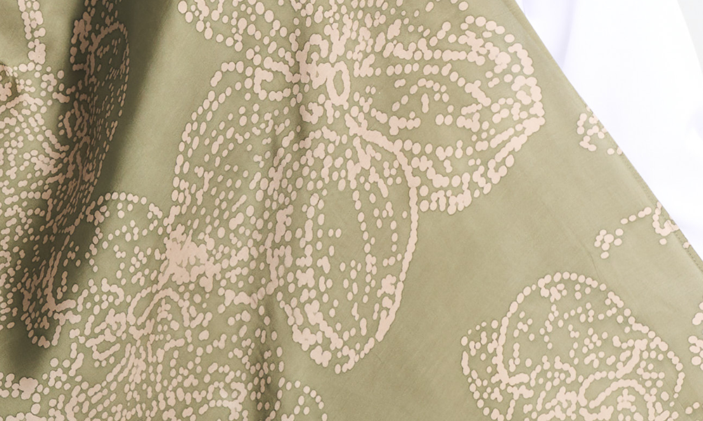 Close-up of the moss green batik scarf with hand-painted orchid motifs