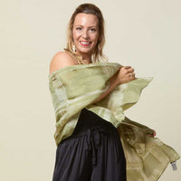 Woman wearing long batik scarf in olive cotton silk.