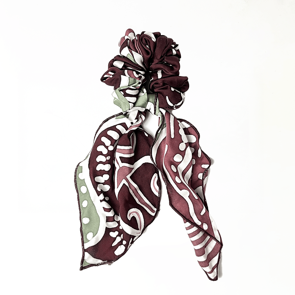 Patterned headband with maroon and white design on a white background
