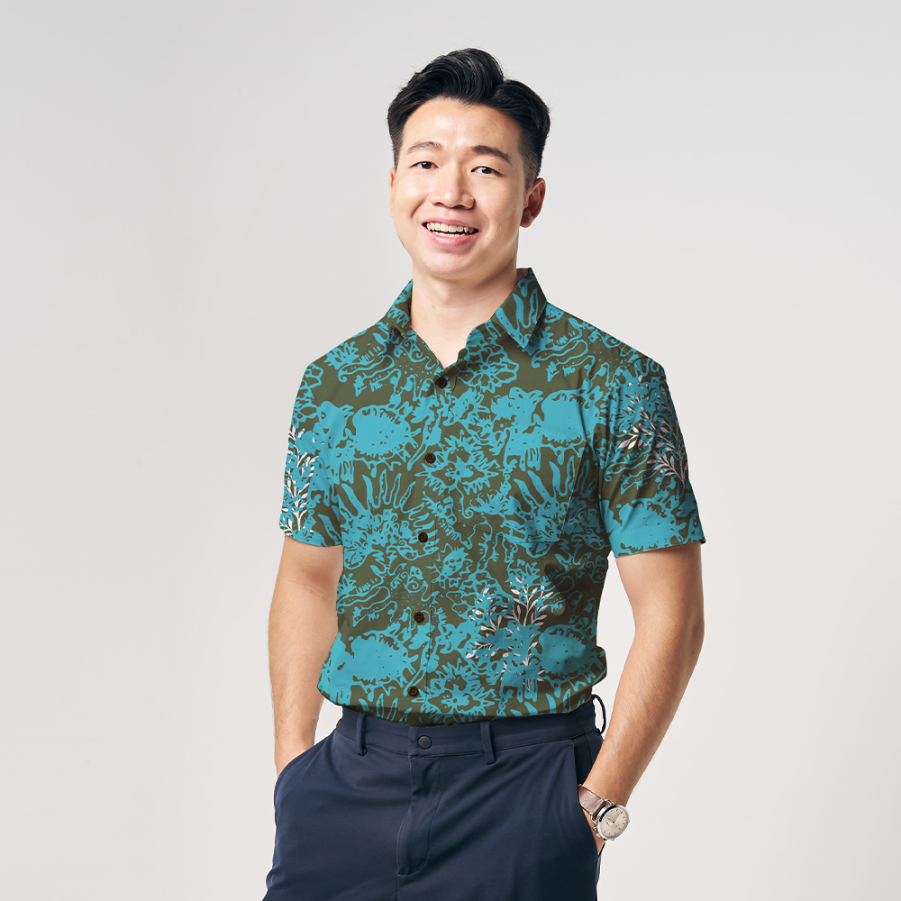 a man wearing a cyan rumpai batik shirt in front of a white background