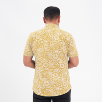 a photo of. a male model facing the back to showcase the details of the floral pattern on an authentic batik shirt in th e pattern mustard ukir