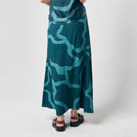 A stylish back view of a long batik skirt, featuring the enchanting Forest Chain pattern, against a neutral background, highlighting the graceful design