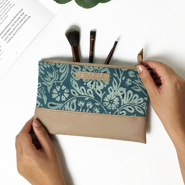 a hand model poses with a batik zip pouch in the pattern  teal ukir