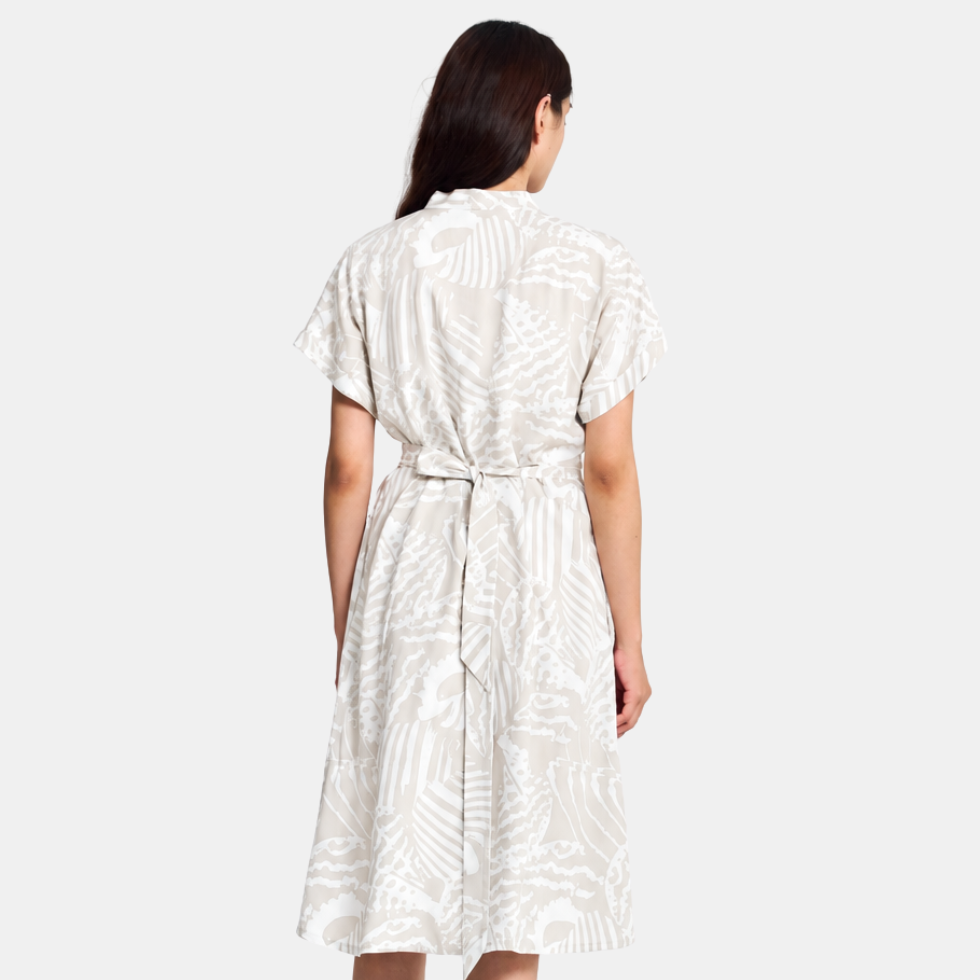 Woman wearing grey printed batik dress facing the back, showing the features of the back of the dress