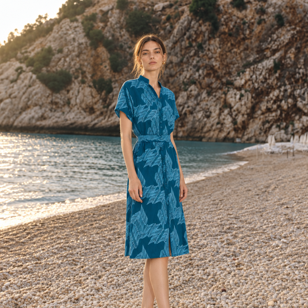 Woman in blue dress standing by the beach