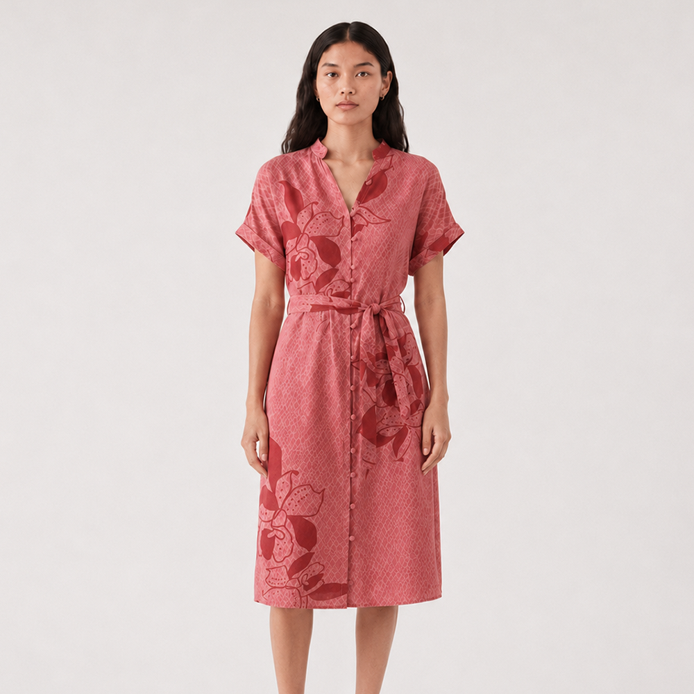 Woman wearing a batik pink dress with floral patterns on a white background