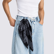 Man wearing black printed batik bandana by his belt loop