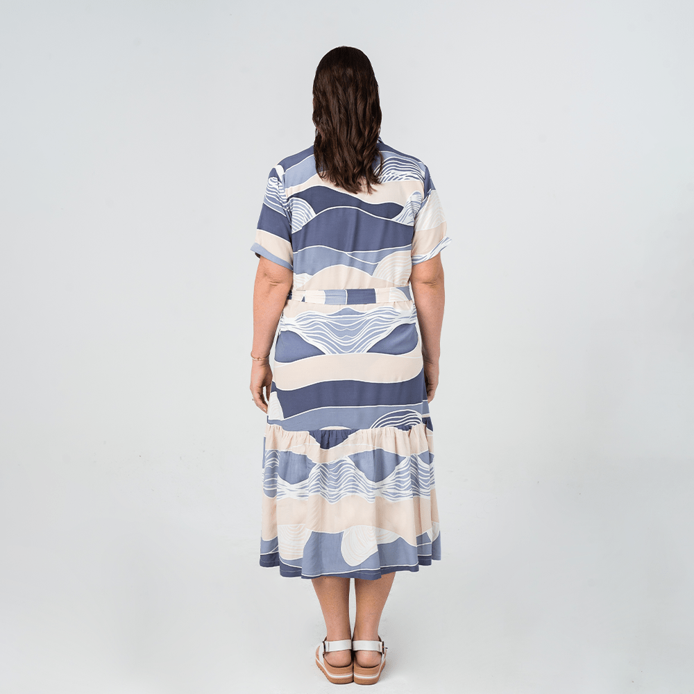 Back view of Batik Boutique’s Button-Up Dress in Lavender Bukit print, featuring a relaxed fit and tiered skirt.