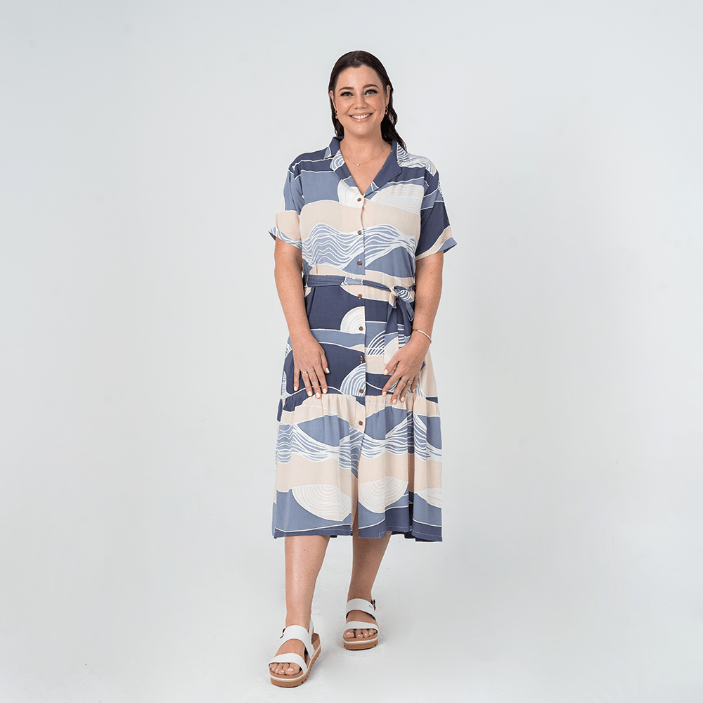 Front view of model wearing Batik Boutique’s Button-Up Dress in Lavender Bukit print, made from breathable cotton with a self-tie waist.