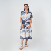 Front view of model wearing Batik Boutique’s Button-Up Dress in Lavender Bukit print, made from breathable cotton with a self-tie waist.