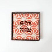 Artisan-crafted peach batik coasters with starburst pattern, set of four coasters, Square cotton coasters featuring peach firework batik design, reversible sides in matching tones, handcrafted by Malaysian artisans. Peach and white batik coasters in starburst motif, reversible fabric with Batik Boutique logo box, ideal for home décor or gifting. Perfect for  drinking, parties, Events
Stocking stuffer