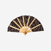A traditional folding hand fan with a black fabric canopy featuring a beige leaf pattern, supported by light natural bamboo ribs, shown against a plain white background.