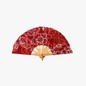 A folding hand fan with a red fabric canopy featuring a white and orange floral pattern, supported by a light wood frame.