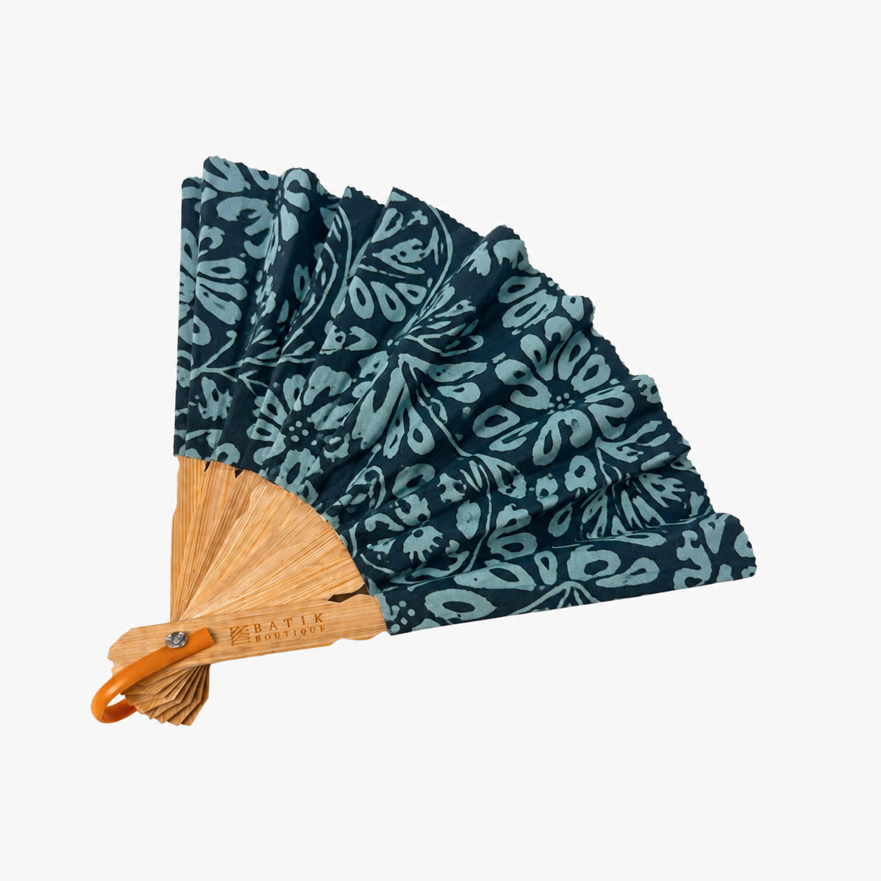A folding hand fan with a dark teal and light blue floral patterned fabric, a natural bamboo handle, and an orange carrying loop, shown on a plain white background.