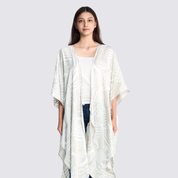 Woman smiling and facing the front, showing the front details of the grey printed batik kimono at the front