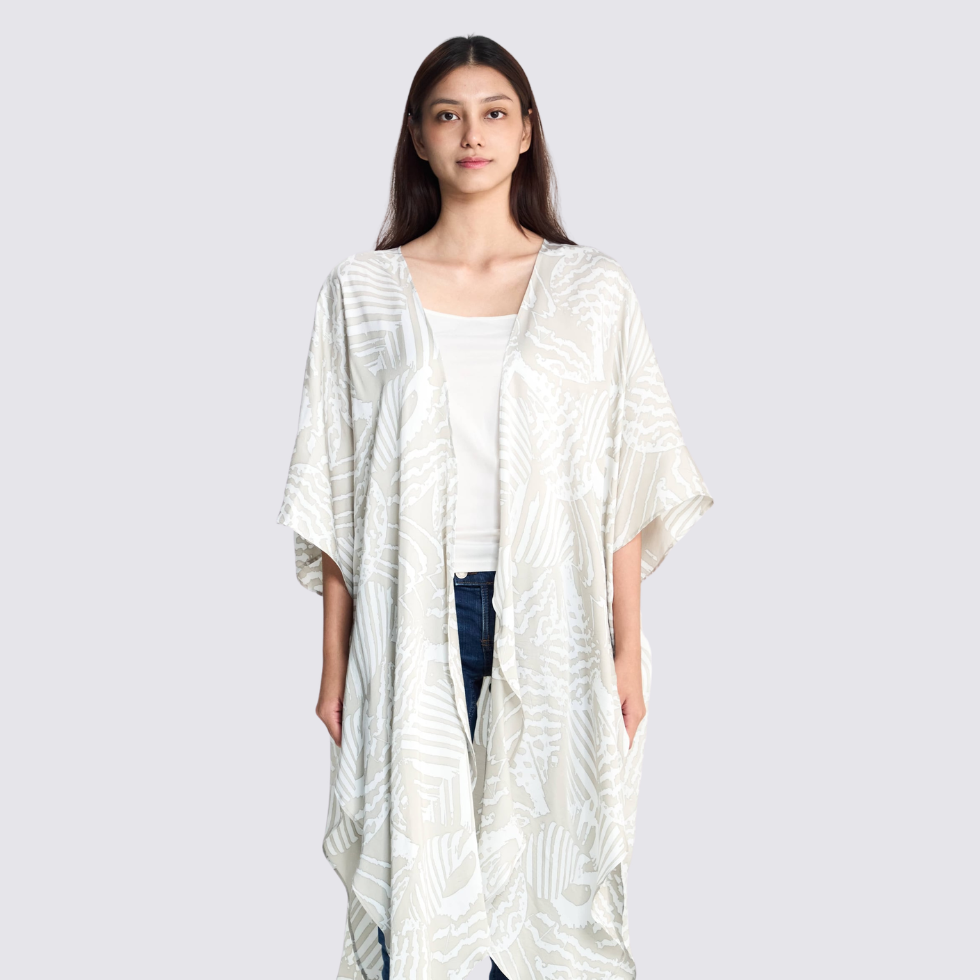 Woman smiling and facing the front, showing the front details of the grey printed batik kimono at the front