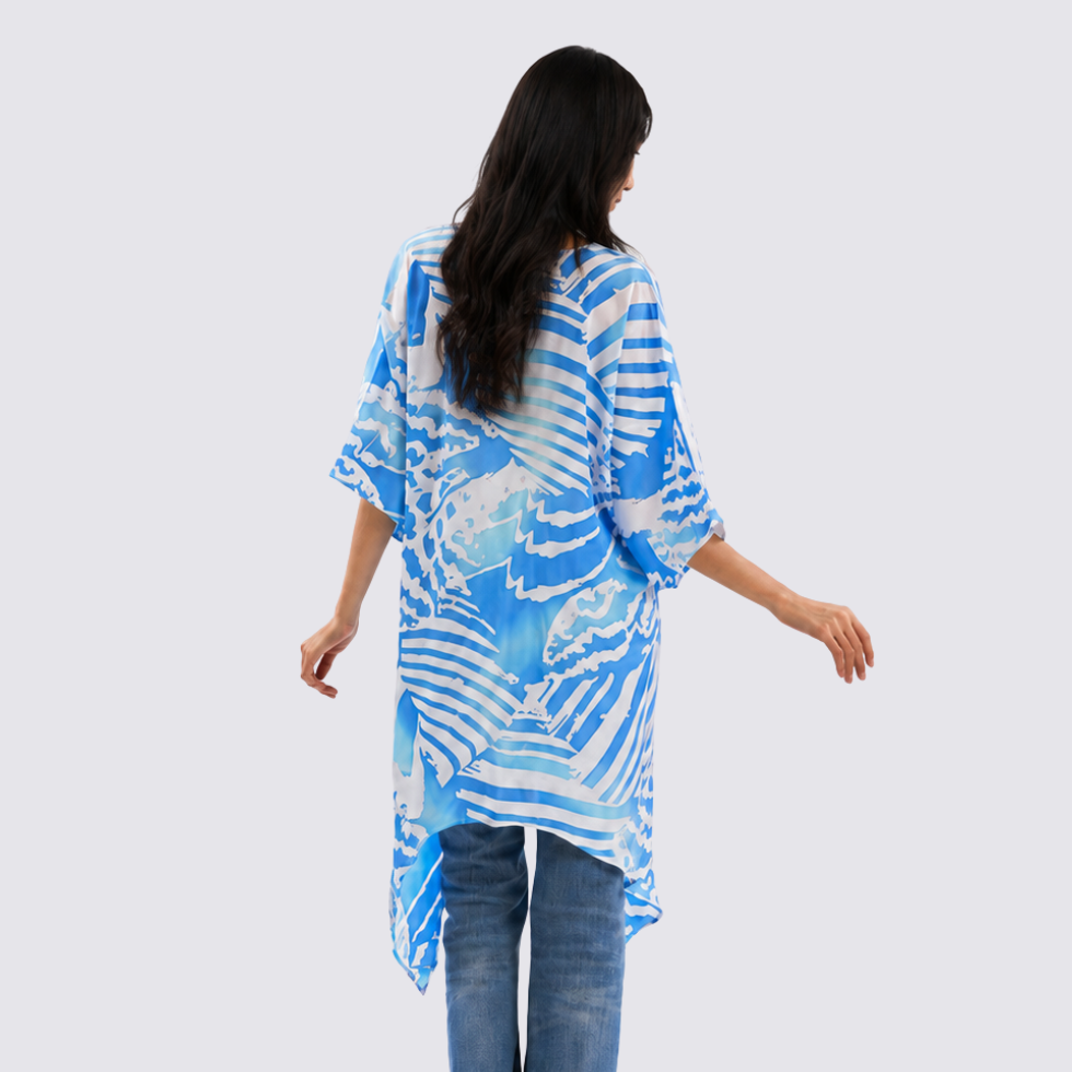 Woman wearing a blue and white patterned kimono-style garment on a white background