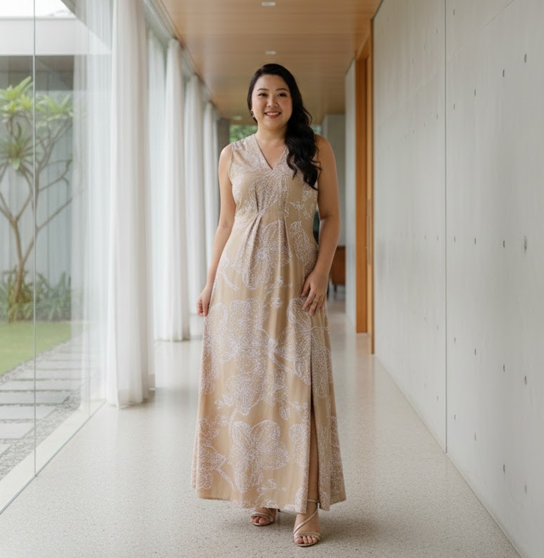 Woman in a beige floral dress standing in a modern indoor setting