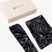 Two batik fabric accessories with a black and white swirling abstract pattern, displayed next to a cream-colored 'BATIK BOUTIQUE' gift box on a clean white background.