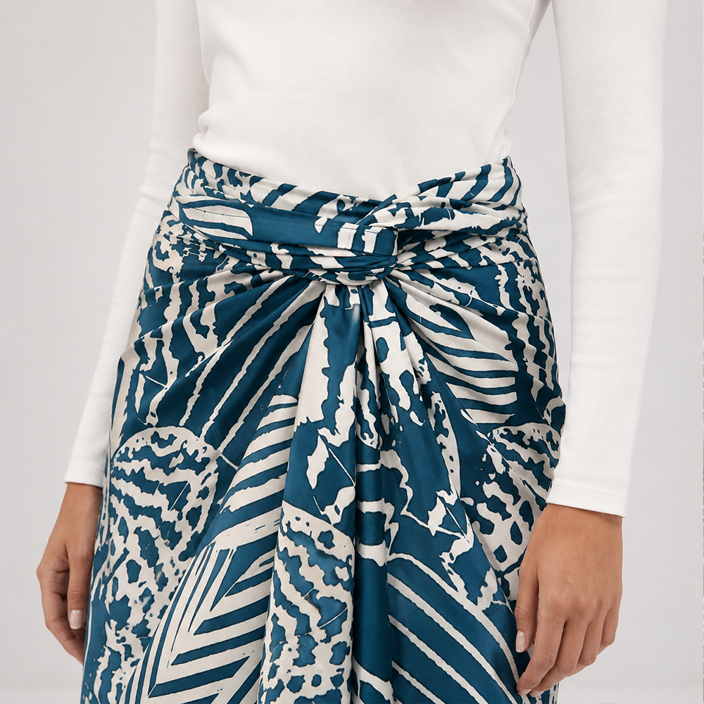 Person wearing a blue and white patterned skirt with a plain background