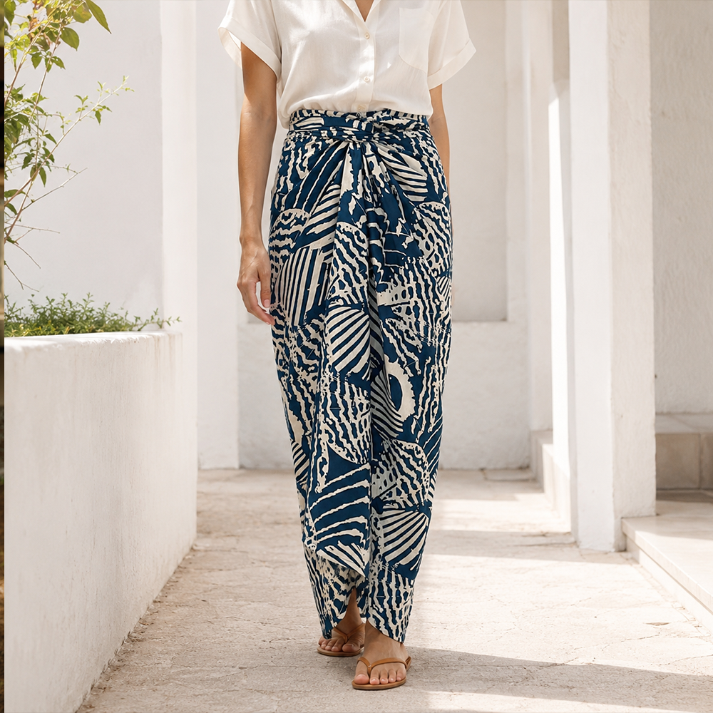 Person wearing blue and white patterned pants on a wooden deck with white walls.