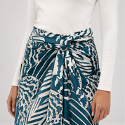 Person wearing a blue and white patterned skirt with a plain background