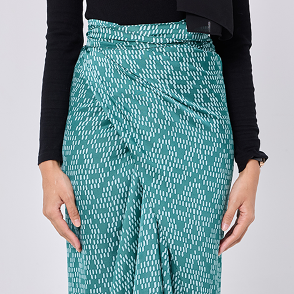 Teal patterned pants worn by a person on a light gray background