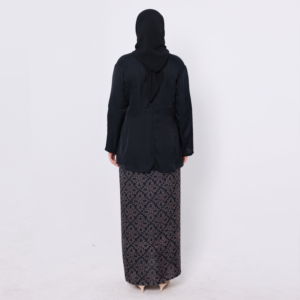 Person wearing a black outfit with a patterned skirt on a white background