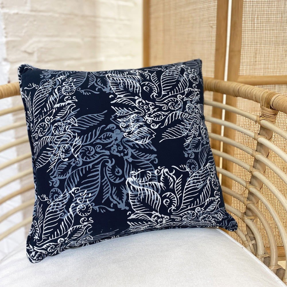 a batik blue nautical fern pillow cover square against a chair