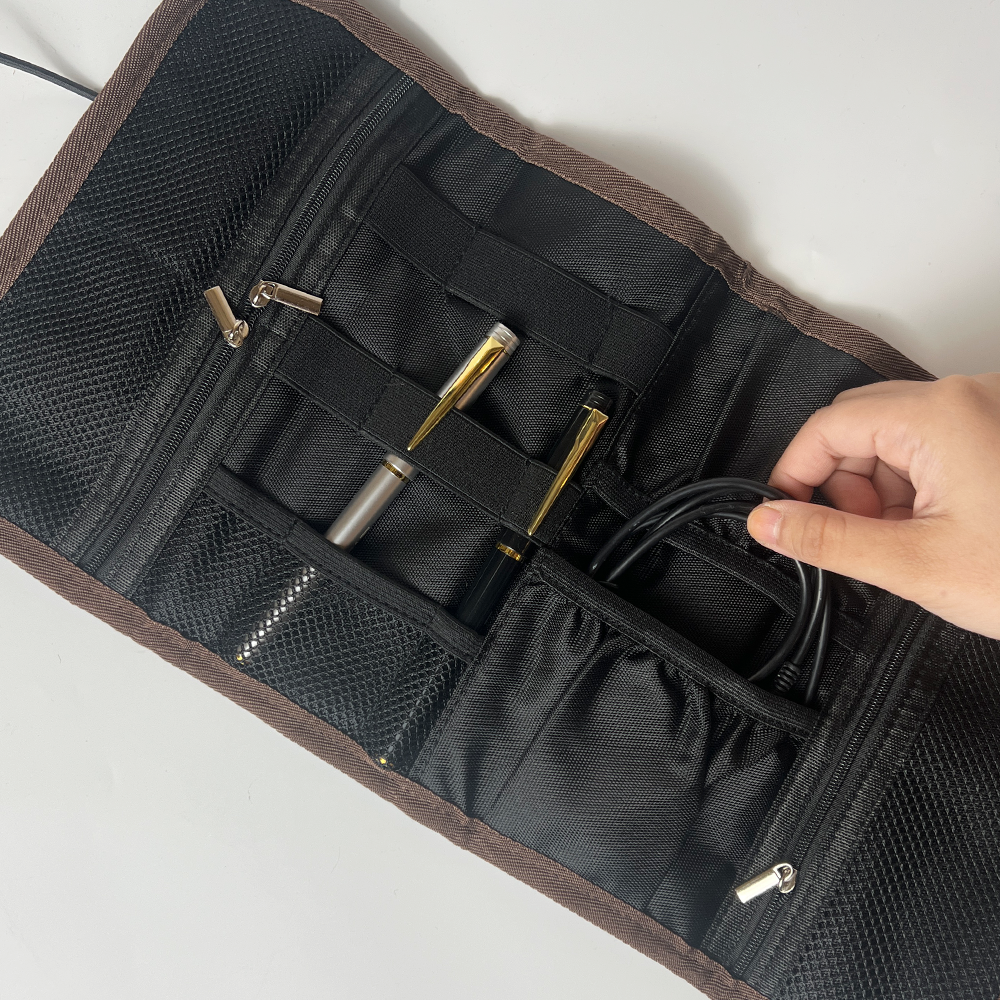 Black knitting needle case with gold needles and a hand reaching in to adjust cables.