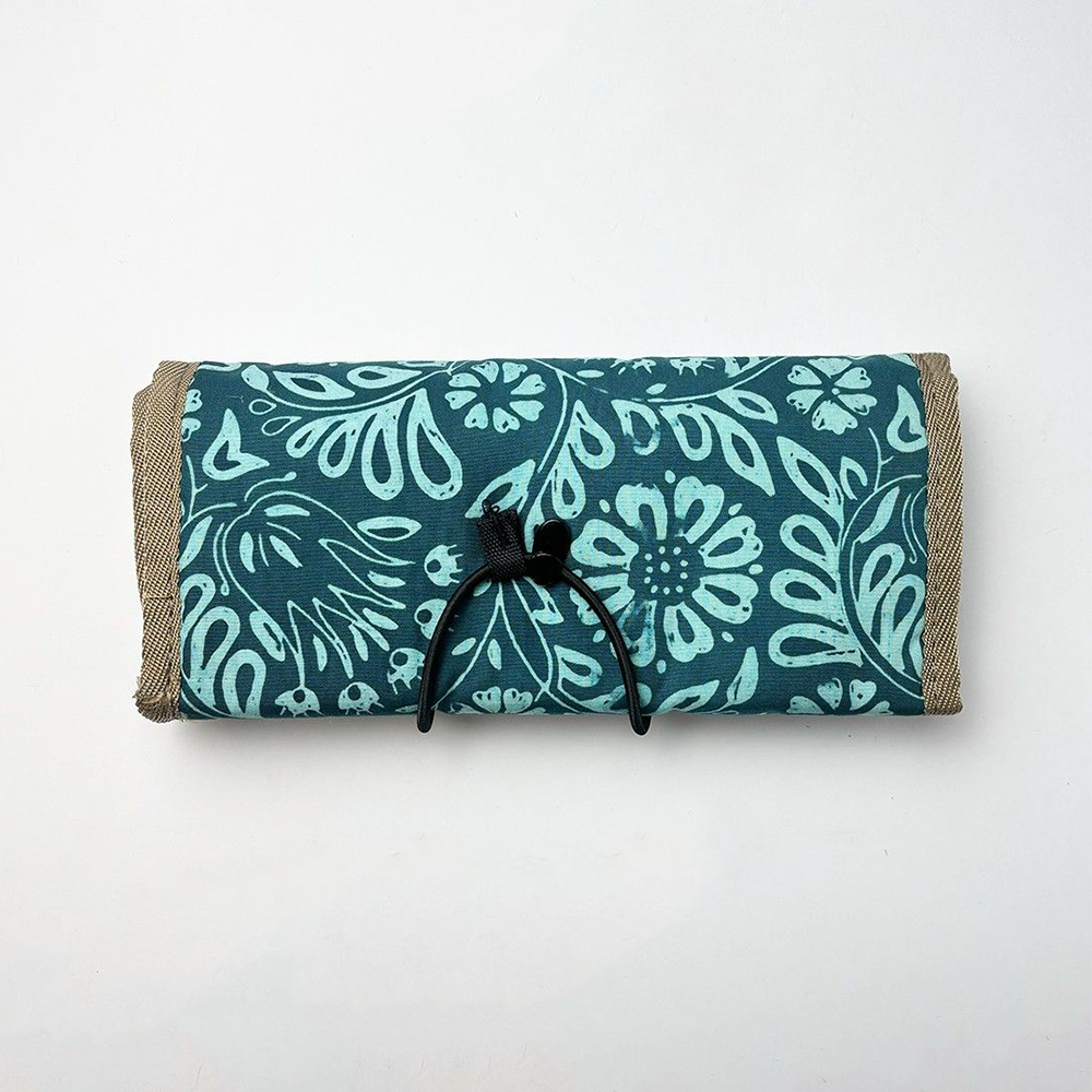 Roll-up mat with teal floral pattern on a white background
