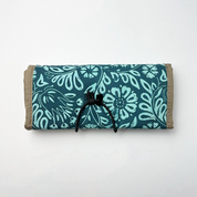 Roll-up mat with teal floral pattern on a white background