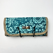 Roll-up fabric mat with teal floral pattern and brown border on a white background