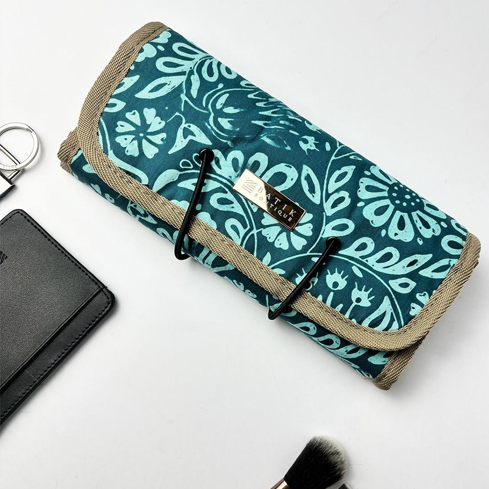 Teal floral-patterned makeup roll with brown trim on a white background