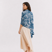 Woman wearing a patterned blue scarf on a white background
