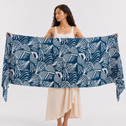 Woman carrying a blue patterned scarf with a plain background