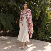 Woman wearing maroon scarf outside by greenery
